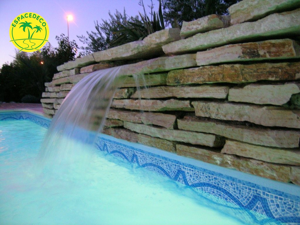 Gros muret avec cascade pour une piscine