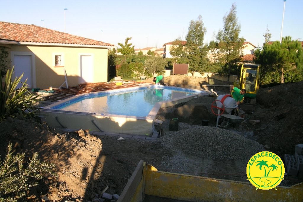 Pose d'un géotextile et de minéraux autour de la piscine.