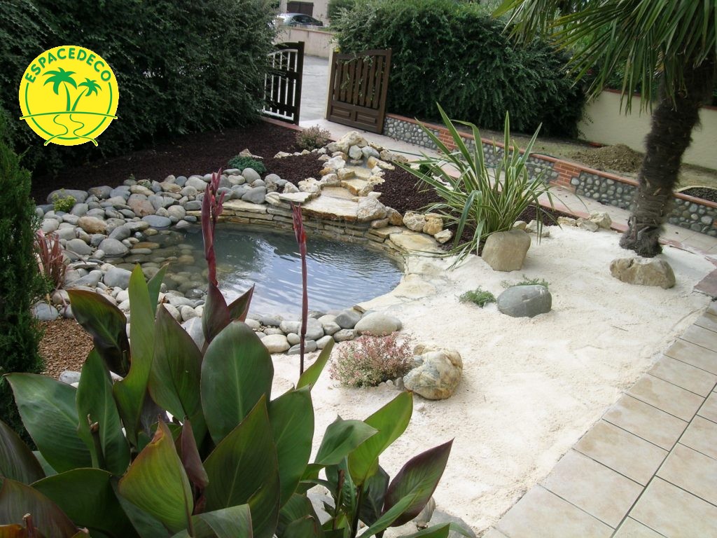 Décoration dans un petit jardin avec son bassin accompagné de minéraux